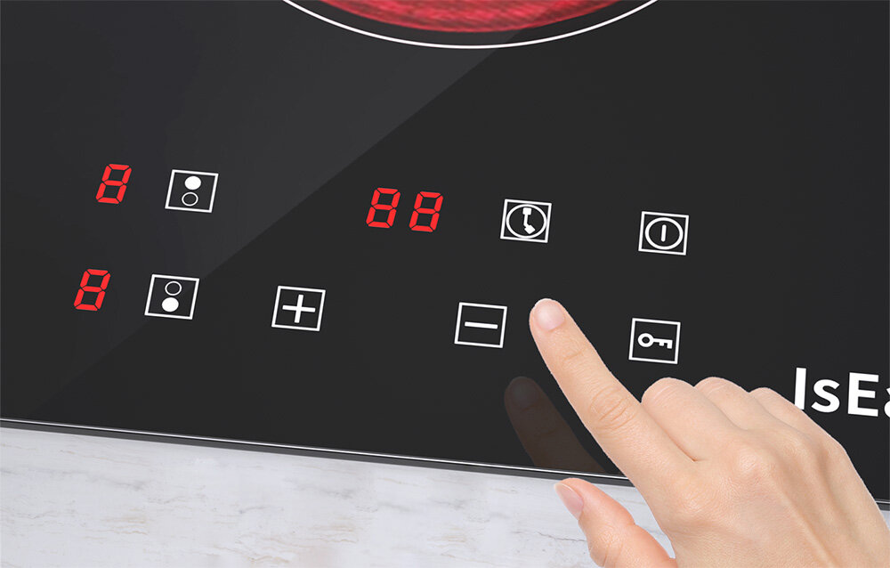 Płyta ceramiczna ISEASY T2V-01M Palec wskazuje ikonę na panelu sterowania płyty, gdzie widoczne są cyfrowe wskaźniki i symbole funkcji. Ujęcie podkreśla łatwość obsługi 9 poziomów mocy timer 99 minut