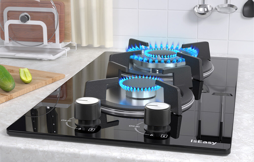 PŁYTA GAZOWA ISEASY MGBG-312A Dwa palniki emitują równy, niebieski płomień, a obok leżą świeże warzywa przygotowane do krojenia. Panel szklany odbija otoczenie, podkreślając klarowność powierzchni wymiary 31x51x11,5 cm montaż 47,5x26,5 cm płyta do zabudowy mała kuchnia