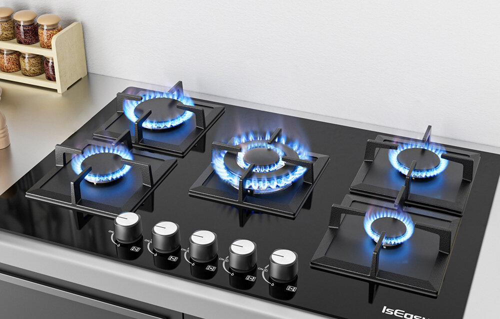 PŁYTA GAZOWA ISEASY MGBG-775S2 Kuchenka z pięcioma zapalonymi palnikami stoi na blacie kuchennym, a płomienie tworzą równy krąg ognia pod naczyniami. Pokrętła sterujące widoczne są na przednim panelu palniki 1kW 1,75kW 2,7kW 3,3kW regulacja mocy elastyczne gotowanie