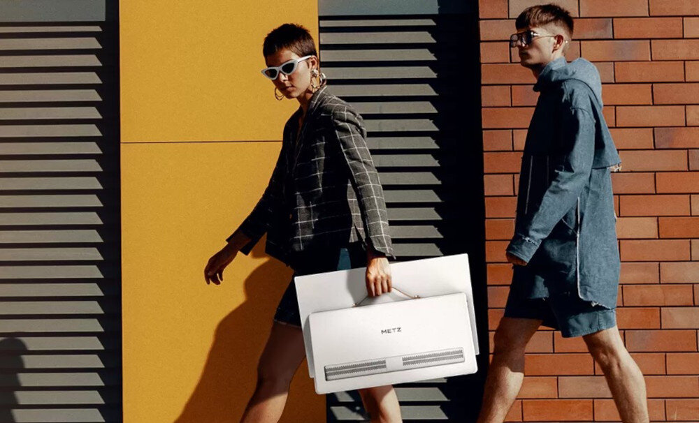 Telewizor METZ 24MPE7000Z uchwyt skórzany mobilność wygoda transport, osoba trzymająca telewizor za uchwyt