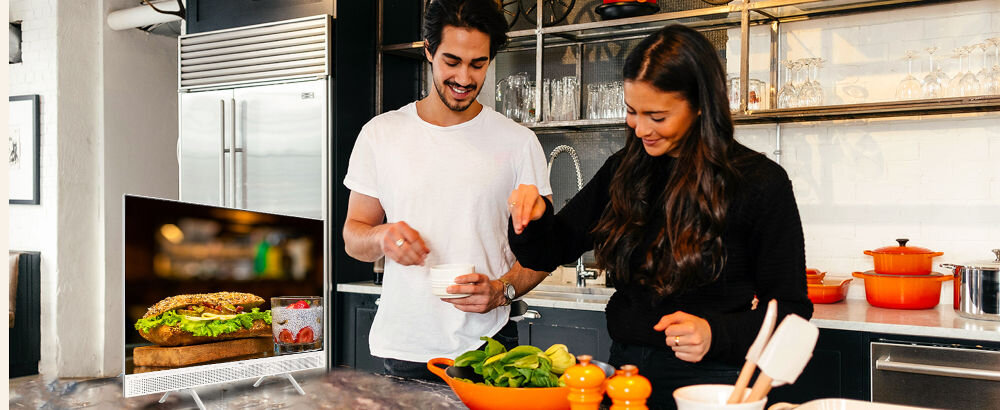 Telewizor METZ 32MTE7000Z tunery DVB-T2 HEVC, telewizor stojący na blacie w kuchni, osoby gotujące posiłek