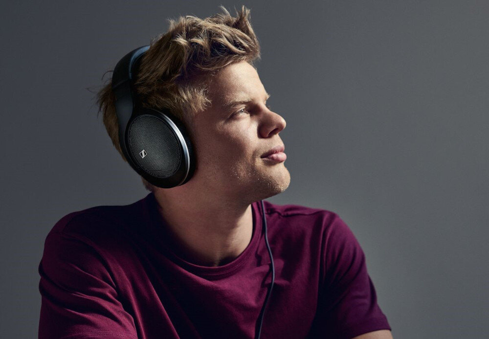 Słuchawki nauszne SENNHEISER HD 550 — dynamika 90 dB, impedancja 150 Ohm, precyzyjne odwzorowanie dźwięku, osoba z założonymi słuchawkami
