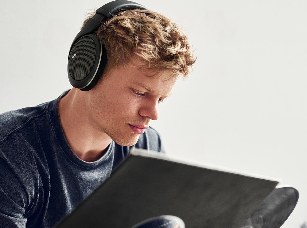 Słuchawki nauszne SENNHEISER HD 550 — lekka konstrukcja 237 g, kabel 1.8 m, komfort nauszny, osoba z założonymi słuchawkami trzymająca w ręku płytę winylową
