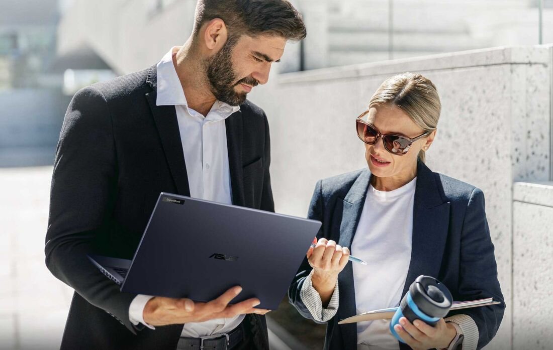 Dwóch profesjonalistów, mężczyzna i kobieta, współpracujących na zewnątrz przy laptopie ASUS ExpertBook B5, podkreślający mobilność, elegancki design i wydajność do pracy zespołowej w dynamicznym środowisku biznesowym . - Kompletny zestaw portów