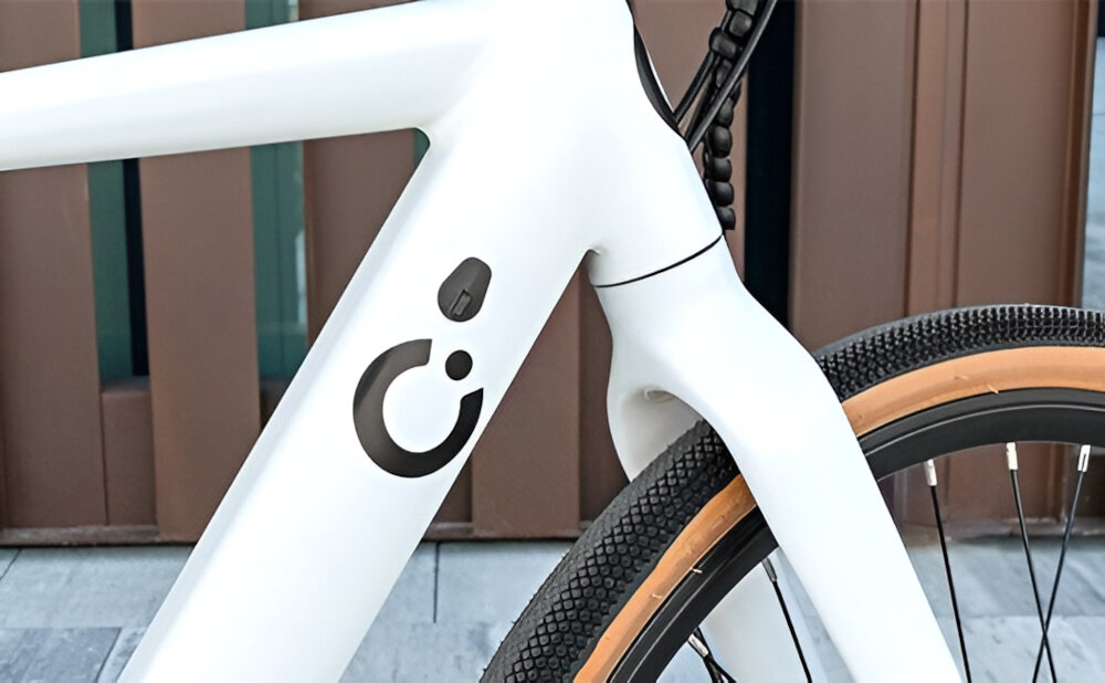 Rower elektryczny CECOTEC Sprint M20 28 cali Biały ściana budynku zbliżenie na baterię w ramie widoczne logo marki zasięg do 70 km bateria litowo-jonowa napięcie 36 V pojemność 10 Ah (360 Wh) czas ładowania około 4-5 godzin żywotność około 1000 ładować umiejscowiona na ramie zintegrowana z konstrukcją roweru