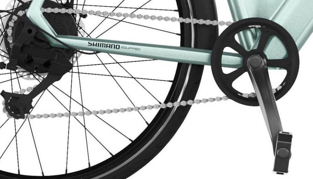 Rower elektryczny CECOTEC Urban D18 28 cali Niebieski białe tło zbliżenie na korbę i wolnobieg lekka i aluminiowa konstrukcja korby marki SHIMANO wolnobieg SHIMANO typu AMFTZ5007428 solidny wytrzyma obciążenie nawet w trudnych warunkach wytrzyma bardzo duży nacisk na pedały