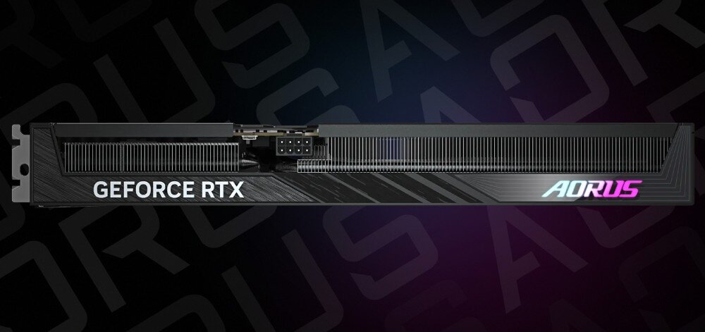 Karta graficzna GIGABYTE Aorus GeForce RTX 5060 Ti Elite 16GB Widok boczny na kartę graficzną z widocznym dużym radiatorem i logiem 'GEFORCE RTX' oraz świecącym napisem 'AORUS', powierzchnia PCB, bezpieczeństwo