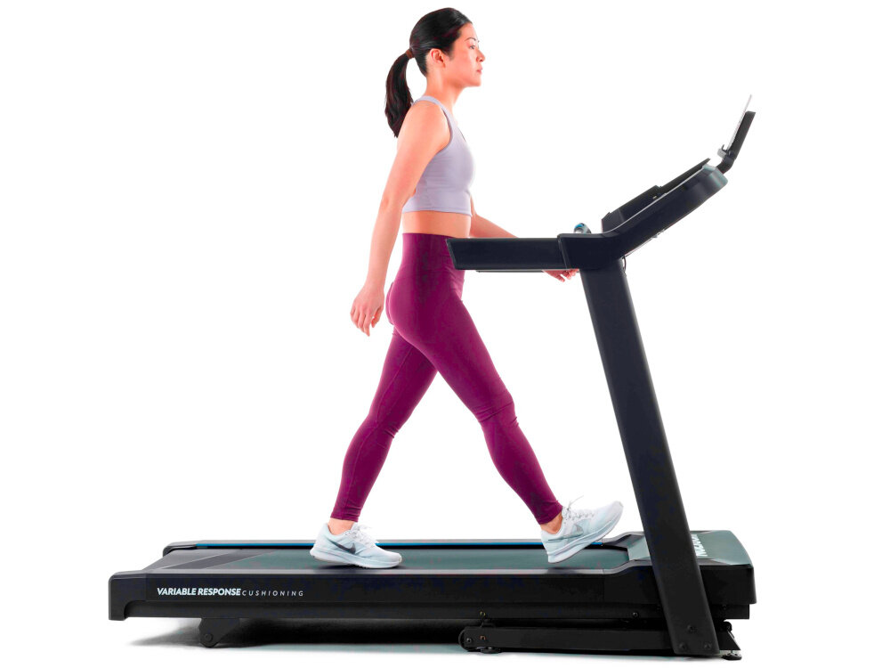 Bieżnia elektryczna HORIZON 5.0AT-21 1864W 16km-h kobieta idzie na bieżni widok z boku zdjęcie na białym tle regulacja prędkości od 0,8 do 16 km/h dopasowanie intensywności ćwiczeń do indywidualnych potrzeb silnik o mocy 1864 W płynna i stabilna praca bezpieczne budowanie formy