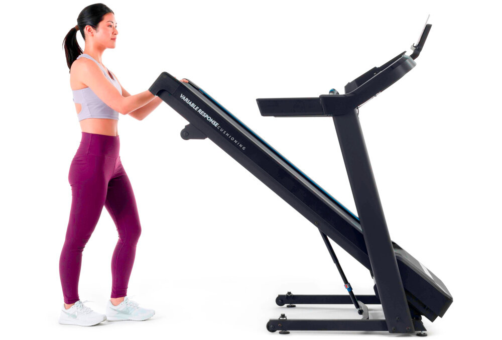 Bieżnia elektryczna HORIZON 5.0AT-21 1864W 16km-h kobieta składa bieżnię zdjęcie na białym tle łatwo złożyć do wymiarów 85 x 154 x 116 cm wbudowane rolki optymalne wykorzystanie przestrzeni składana konstrukcja ułatwia przechowywanie i dostępność sprzętu