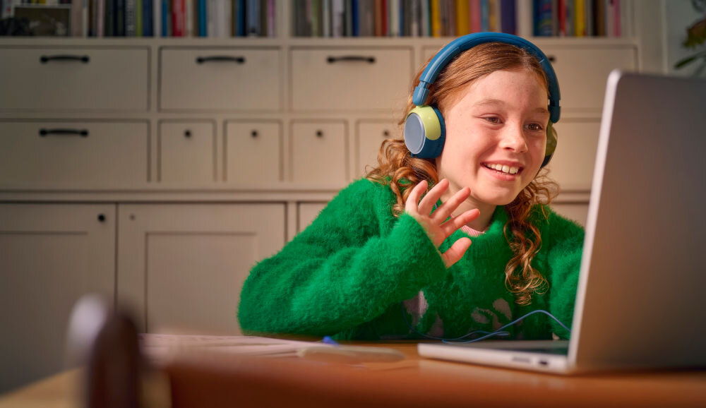 Słuchawki nauszne PHILIPS TAK2000MP port udostępniania dźwięku dla dzieci, dziecko z założonymi słuchawkami siedzące przy laptopie