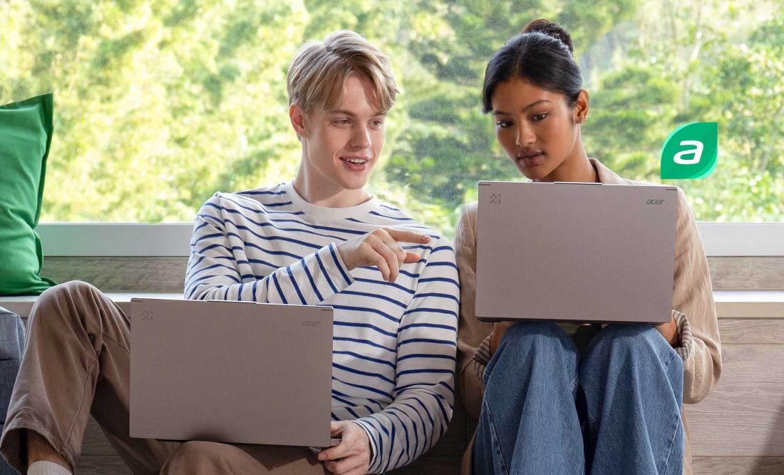 Dwie osoby siedzące przy oknie z laptopami Acer Aspire 14 AI, jasne wnętrze, zielone poduszki, logo Acer w tle – ultrabook do pracy i nauki w komfortowym otoczeniu  