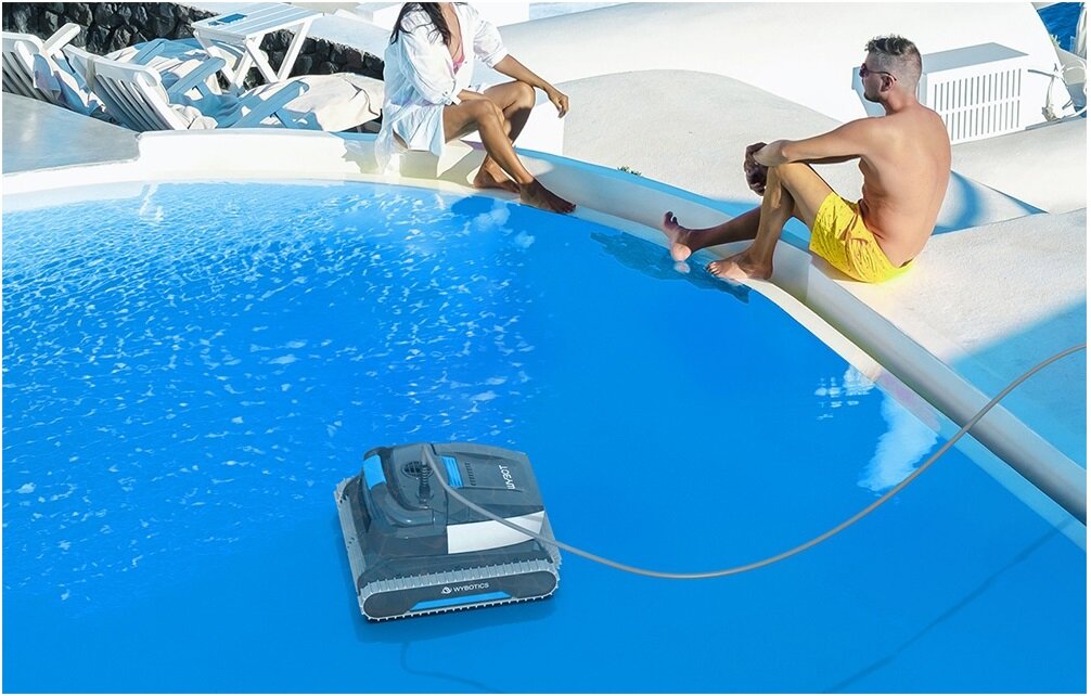 Robot do czyszczenia basenów WYBOT L1, basen, czyszczenie, porządek, sprzątanie, para siedzi na krawędzi basenu, na dnie basenu pracuje robot