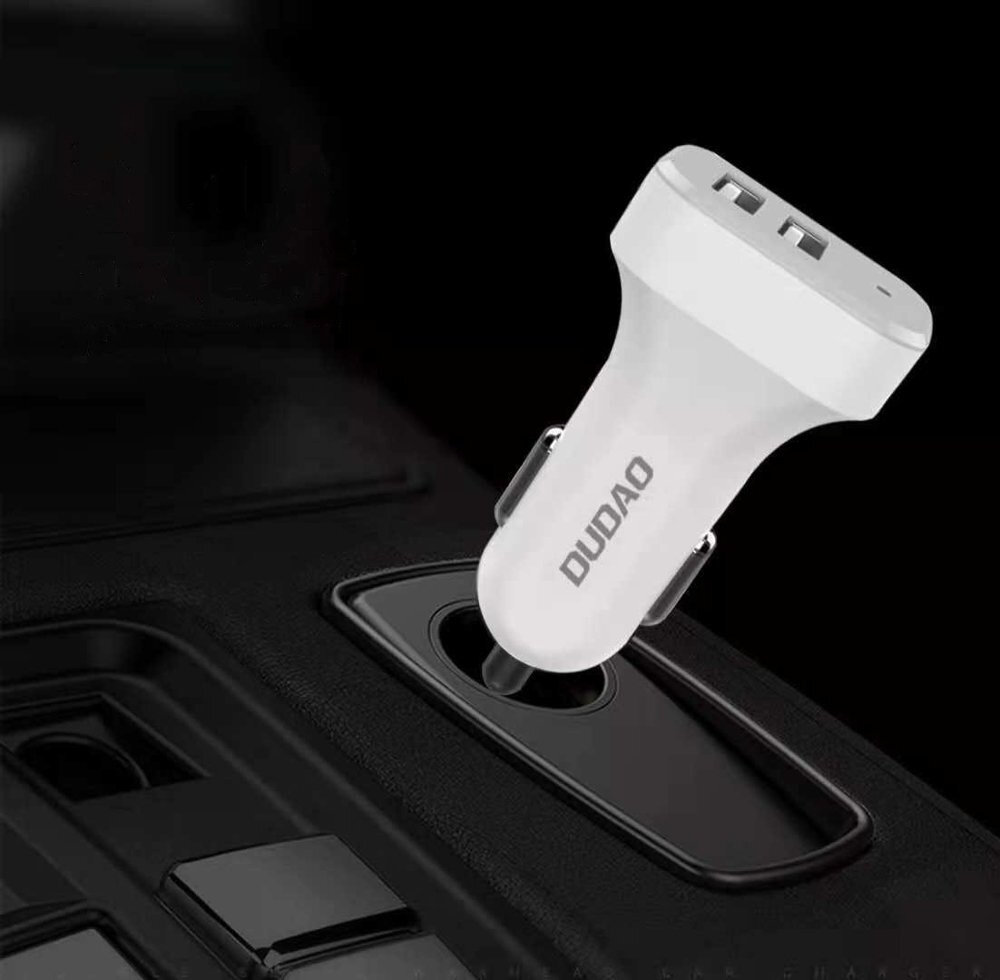 Biała ładowarka samochodowa z dwoma portami USB jest włożona do gniazda zapalniczki. Na ładowarce widoczny jest napis \'DUDAO\'.