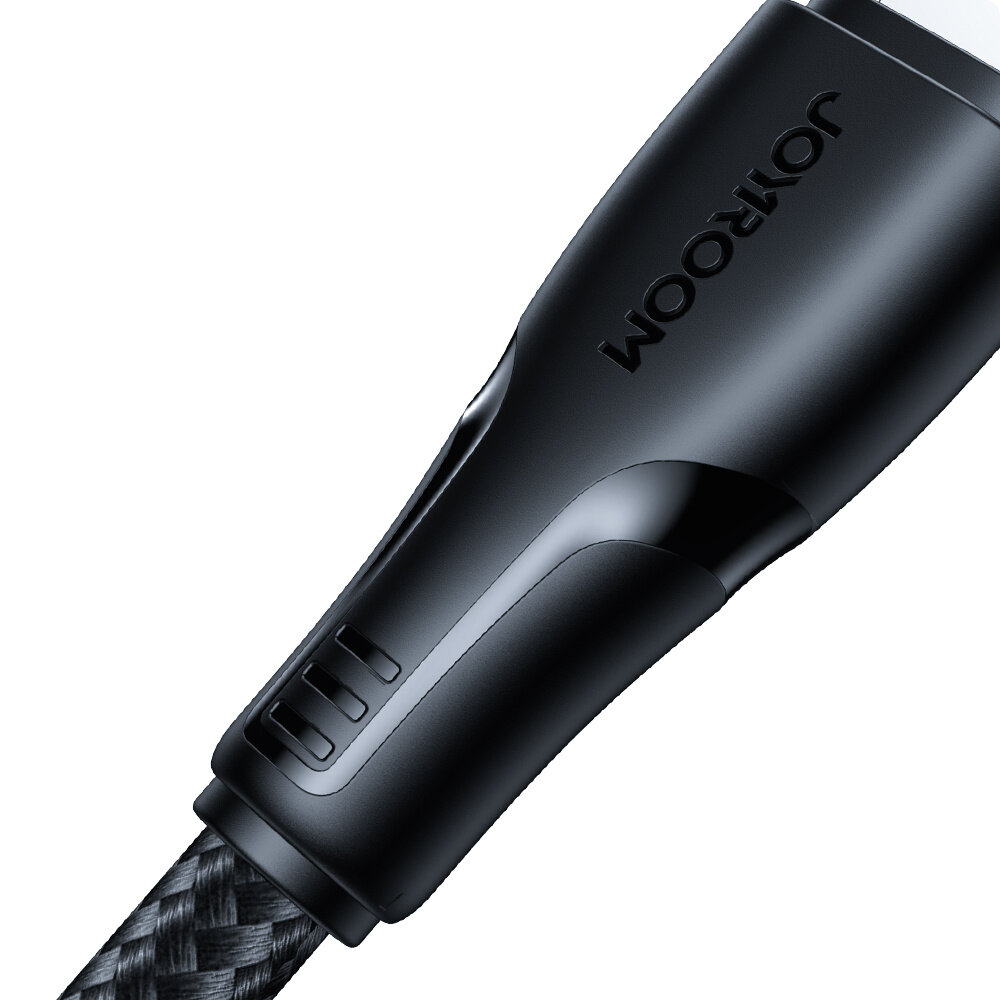 Zbliżenie na czarną końcówkę kabla z widocznym napisem \'JOYROOM\'. Kabel ma nylonowy oplot w kolorze czarnym.