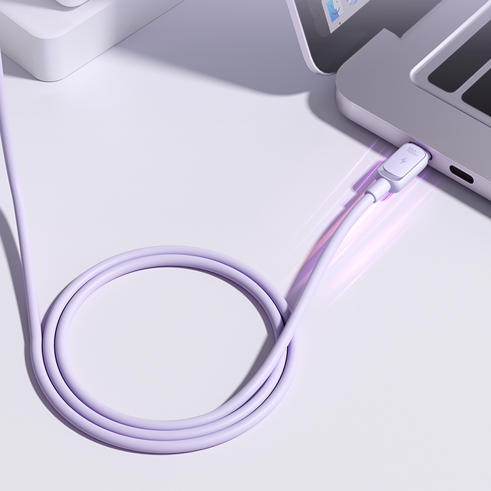Fioletowy kabel USB C - USB C podłączony do laptopa, z widocznym zwojem na powierzchni. Na wtyczce znajduje się symbol błyskawicy i napis \'100W\'.