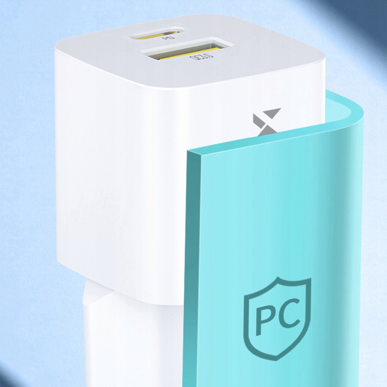 Biała ładowarka sieciowa z dwoma portami: USB-A i USB-C, oznaczonymi jako \'PD\' i \'QC3.0\'. Obok ładowarki znajduje się niebieski element z symbolem tarczy i literami \'PC\'.