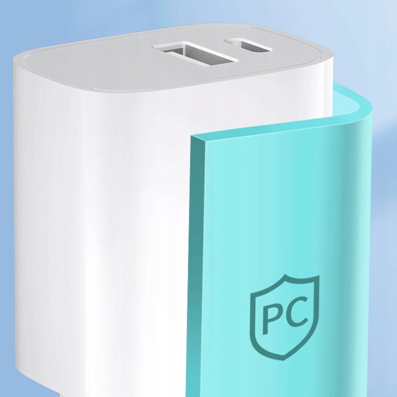 Biała ładowarka sieciowa z dwoma portami: USB-A i USB-C. Na turkusowej części obudowy widoczny jest symbol tarczy z literami \'PC\'.