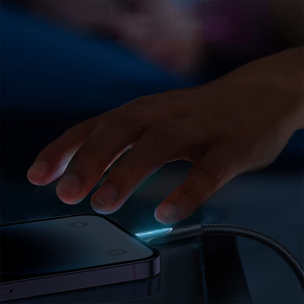 Na ciemnym tle widać rękę zbliżającą się do smartfona, który jest podłączony do kabla USB-C/Lightning. Kabel ma plecioną osłonę i świecący wtyk.