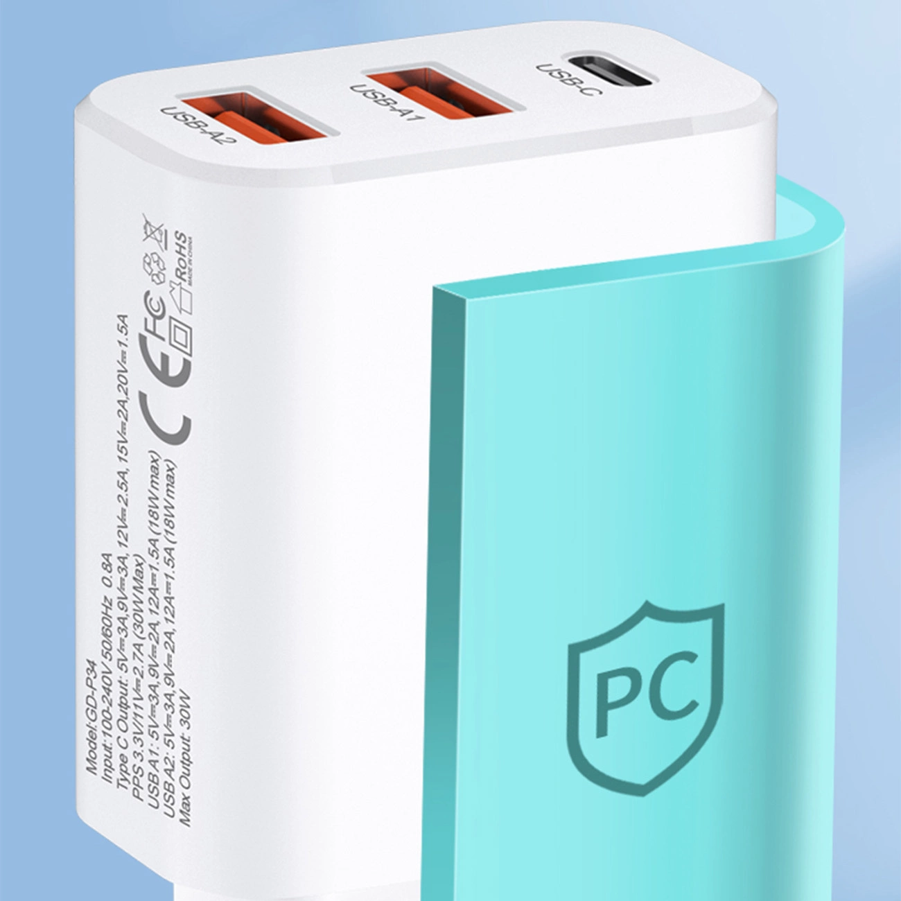 Biała ładowarka sieciowa z trzema portami: USB-C oraz dwoma USB-A, z oznaczeniami \'USB-C\', \'USB-A1\', \'USB-A2\'. Na boku widoczne są specyfikacje techniczne oraz symbole certyfikacji, a obok znajduje się niebieski element z symbolem tarczy i literami \'PC\'.