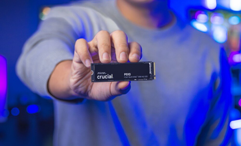 Dysk CRUCIAL P510 Kobieta z blond lokami trzyma w palcach dysk 'crucial P510' i uśmiecha się, patrząc przed siebie, jakość, żywotność