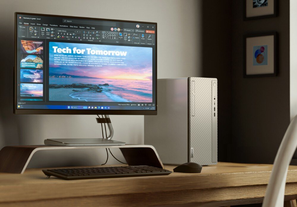 Komputer LENOVO IdeaCentre Tower 14IRR9 Srebrny komputer stacjonarny obok monitora stojącego na podwyższeniu na drewnianym biurku, na ekranie wyświetlona jest prezentacja z tytułem 'Tech for Tomorrow', pamięć, dysk