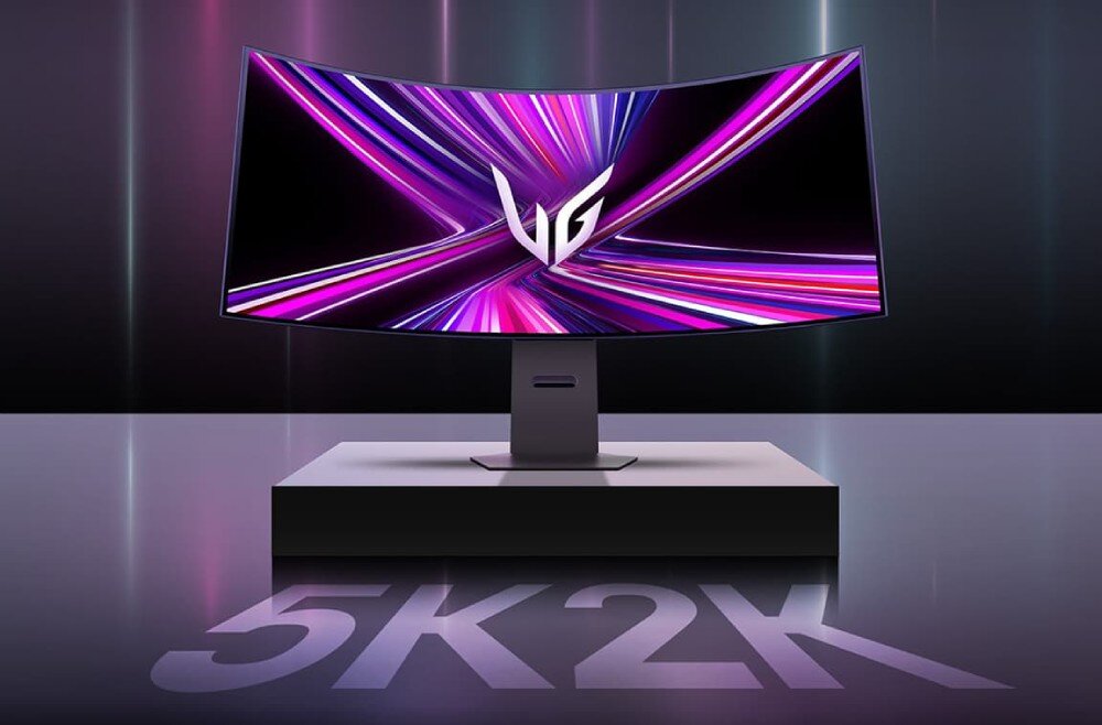 Monitor LG UltraGear 45GX950A-B.AEU Zakrzywiony monitor z logo 'UG' na środku ekranu. W tle dynamiczna grafika z różowo-fioletowymi liniami. Na podstawie napis '5K2K', opis