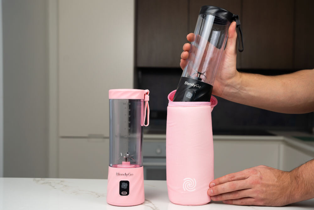 Etui termiczne BLENDYGO do BlendyGo 3 Różowy różowe okrągłe etui zamek logo obok stoi różowy blender osoba wkłada czarny blender do różowego etui z myślą o miłośnikach aktywnego stylu życia podczas podróży intensywnych treningów w pełnych wyzwań dniach pracy w optymalnym stanie składniki przechowywane w blenderze ochrona świeżość