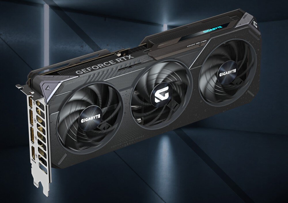 Karta graficzna GIGABYTE GeForce RTX 5060 Ti Gaming OC 8GB Ujęcie karty pod kątem, widoczna obudowa z teksturą mechanicznego pancerza i metalowy panel z portami wyjściowymi, układ graficzny, rdzenie CUDA, taktowanie, technologie, pamięć