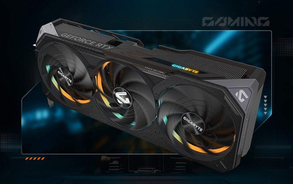 Komputer MAD DOG Powered by Gigabyte AORUS301-I14WR32WP Karta graficzna z trzema wentylatorami, podświetleniem RGB i oznaczeniem 'GIGABYTE' oraz 'GeForce RTX', ustawiona na tle w stylu futurystycznym, karta graficzna, rdzenie CUDA, architektura, pamięć VRAM, wentylatory