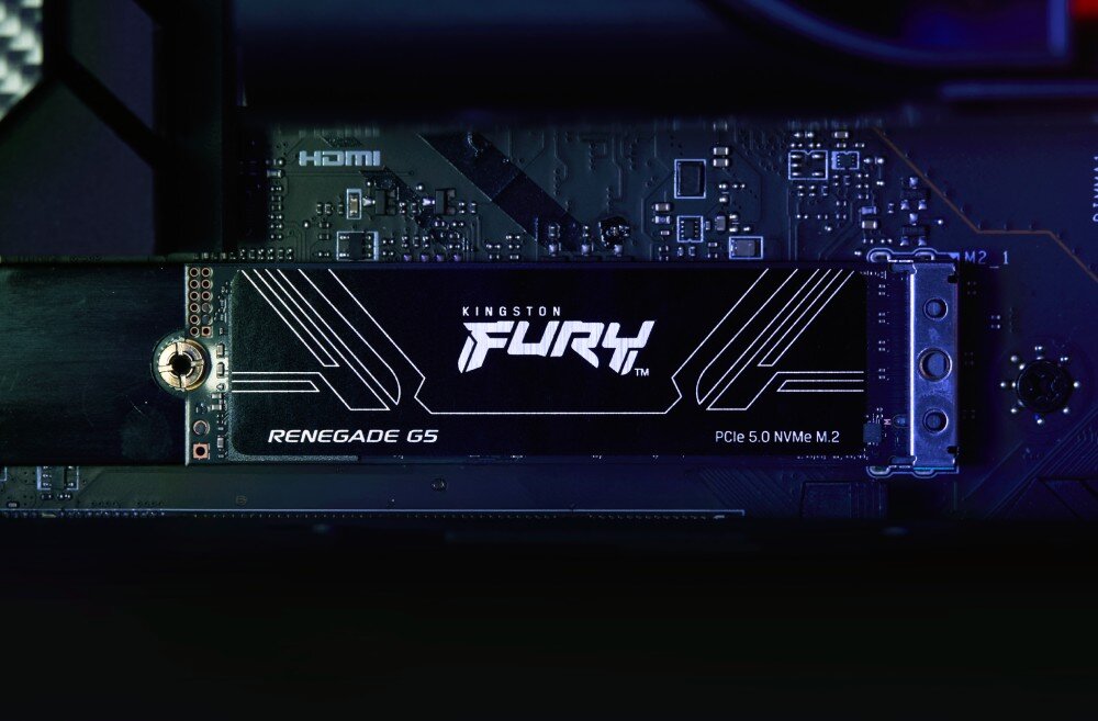 Na obrazie widoczny jest dysk SSD z napisem \'KINGSTON FURY Renegade G5 PCIe 5.0 NVMe M.2\' zamontowany na płycie głównej. W tle widać elementy elektroniczne oraz napis \'HDMI\'.