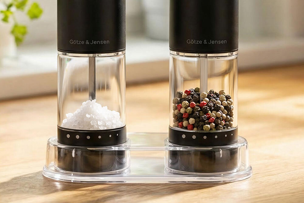 Zestaw młynków do przypraw GÖTZE & JENSEN KA420 Zbliżenie na dolną część młynków Götze & Jensen z widoczną regulacją grubości mielenia oznaczoną kropkami oraz przezroczystymi zbiornikami na sól i pieprz.