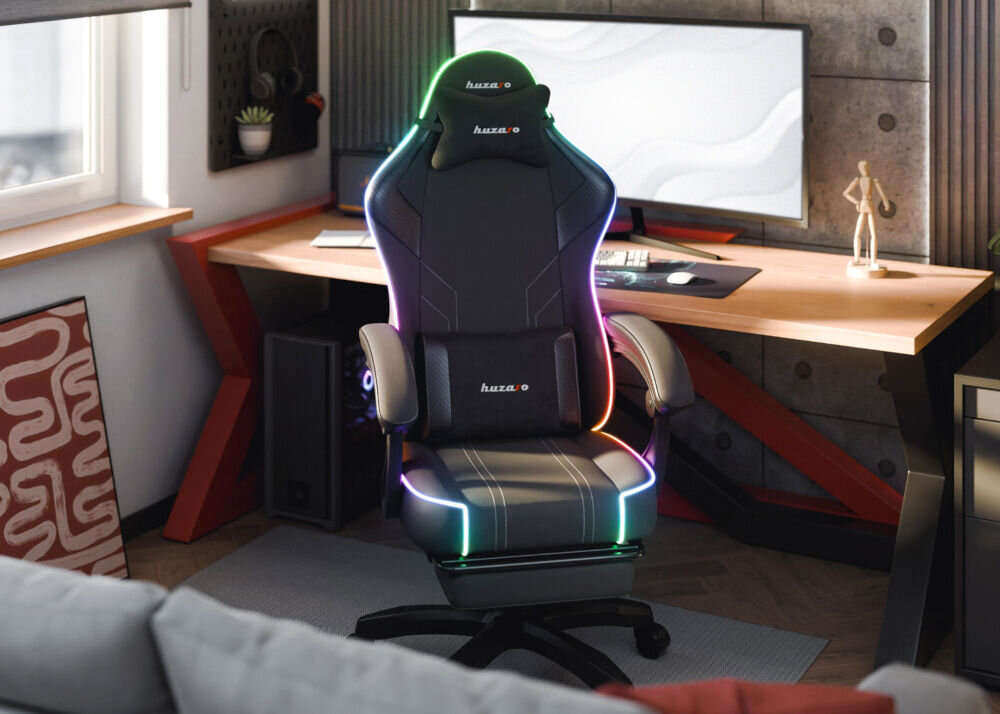 Fotel HUZARO Force 3.7 RGB Czarny prezentacja fotela od przodu w pokoju przy biurku na biurku duży monitor szara kanapa przed fotelem