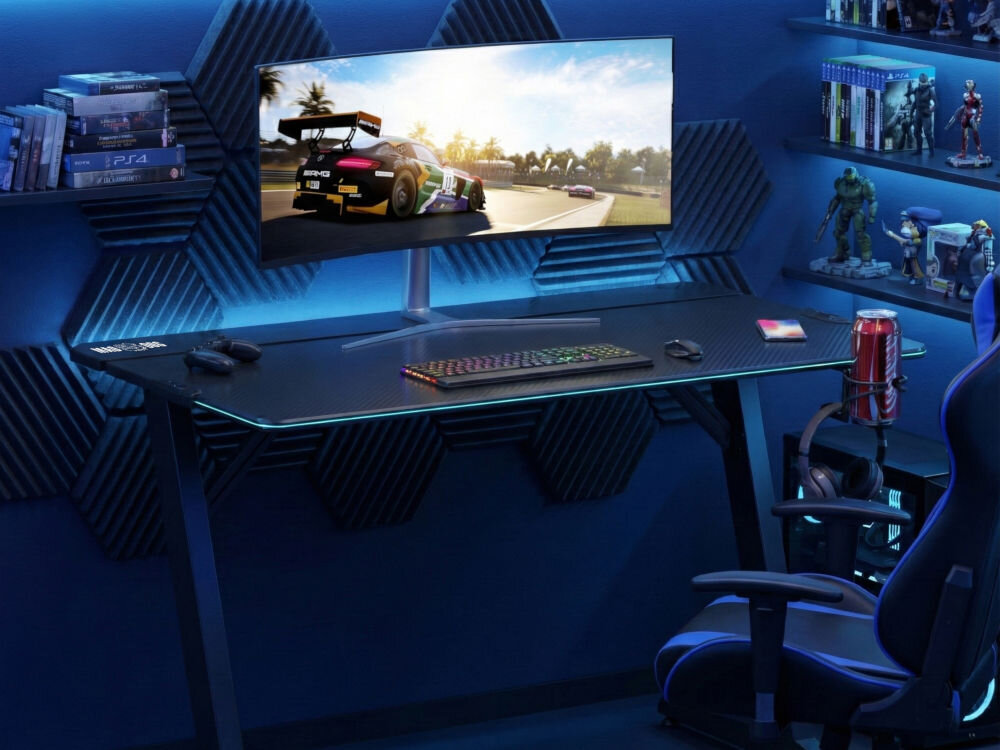 Biurko MAD DOG GD100K Czarne biurko gamingowe z karbonowym blatem i krawędziami LED RGB w ciemnym pokoju z niebieskim oświetleniem