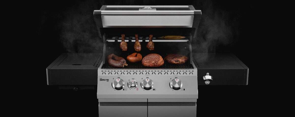 Grill gazowy z otwartą pokrywą, na ruszcie znajdują się różne rodzaje mięsa. Widoczne są cztery pokrętła do regulacji temperatury oraz logo \'media expert\'.