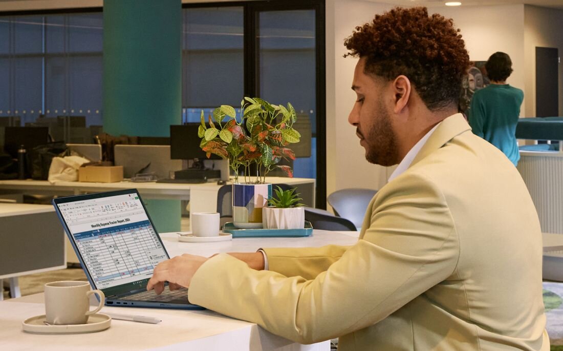 Mężczyzna w beżowym swetrze pracujący na laptopie HP z arkuszem kalkulacyjnym w nowoczesnym biurze. - polimerowy akumulator litowo-jonowy HP Long Life o pojemności 68 Wh