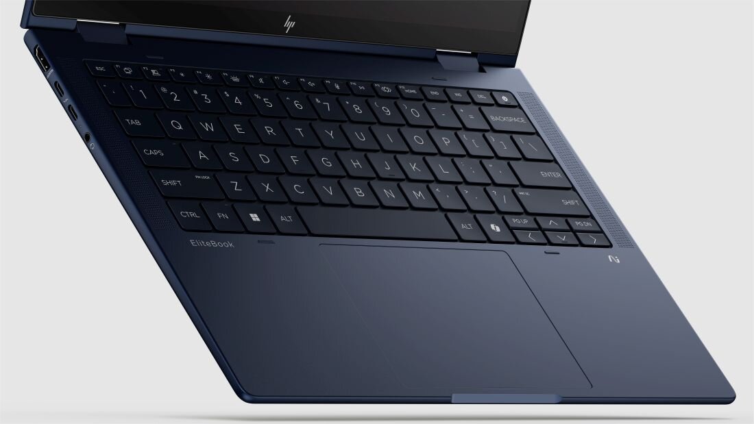 Klawiatura laptopa HP EliteBook z czarnymi klawiszami i dużym touchpadem w ciemnoniebieskiej obudowie. - klawiatura HP Premium z białym podświetleniem