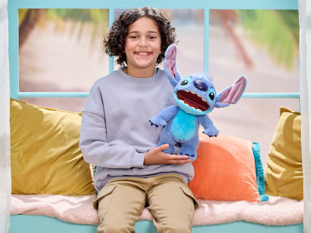 Maskotka WOW Disney Stitch Chatty DIS-1025-01 z otwartą buzią trzymana przez uśmiechnięte dziecko