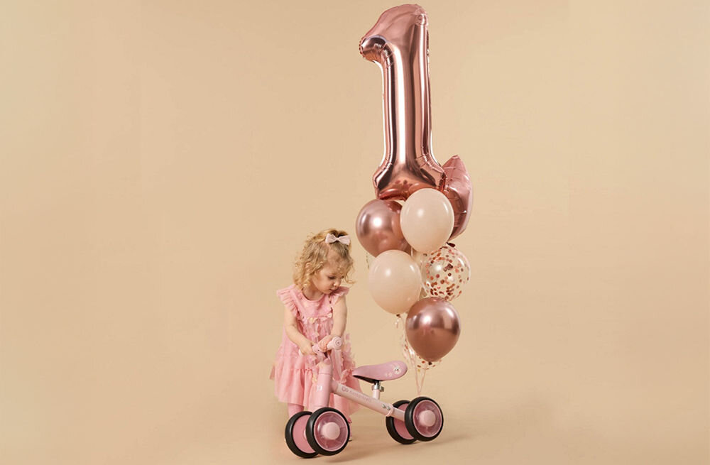 ROWEREK BIEGOWY KINDERKRAFT CUTIE FLASH PINK beżowe tło dziewczynka balon różowy rowerek kółka gumowe uchwyty pierwsza jazda