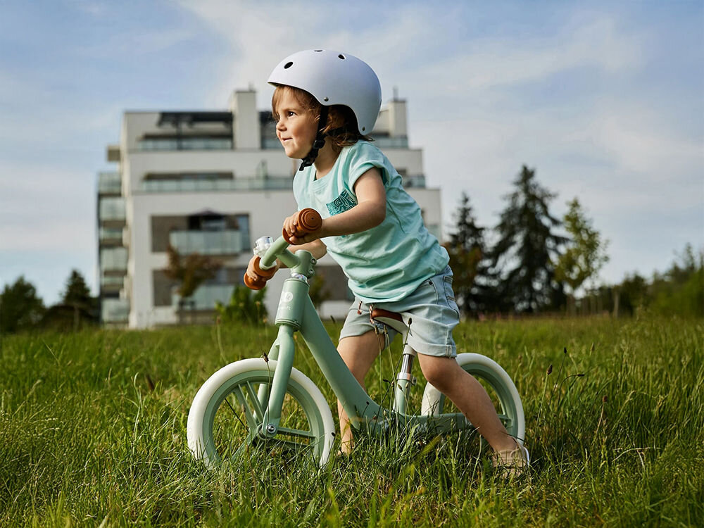 Rowerek biegowy KINDERKRAFT Fly Plus Błękitny dziecko w kasku jedzie na miętowym rowerku dla maluchów już od 2 roku życia (maksymalne obciążenie 35 kg) ergonomiczna konstrukcja do potrzeb maluchów rozwój równowagi koordynacji ruchowej jednoelementowa rama swobodne sterowanie pojazdem zdolności motoryczne orientację w przestrzeni do nauki jazdy na klasycznym rowerze