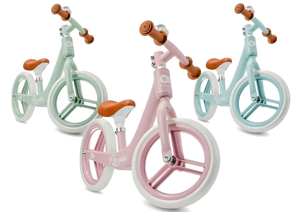 Rowerek biegowy KINDERKRAFT Fly Plus Różowy radość z jazdy białe tło trzy rowery miętowy różowy błękitny jasne koła dzwonek gumowe rączki brązowe siedzisko 