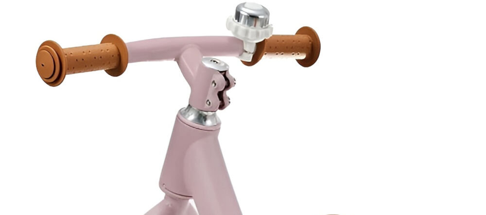 Rowerek biegowy KINDERKRAFT Fly Plus Różowy zbliżenie na kierownicę jasne obudowa dzwonek białe tło stylowy dzwonek umieszczony na kierownicy funkcja rozrywkowa i edukacyjna radosny akcent praktyczne narzędzie nauka zasad bezpiecznego poruszania się maluch może sygnalizować swoją obecność rozwijając świadomość komunikacyjną kształtując dobre nawyki retro stylistyka 