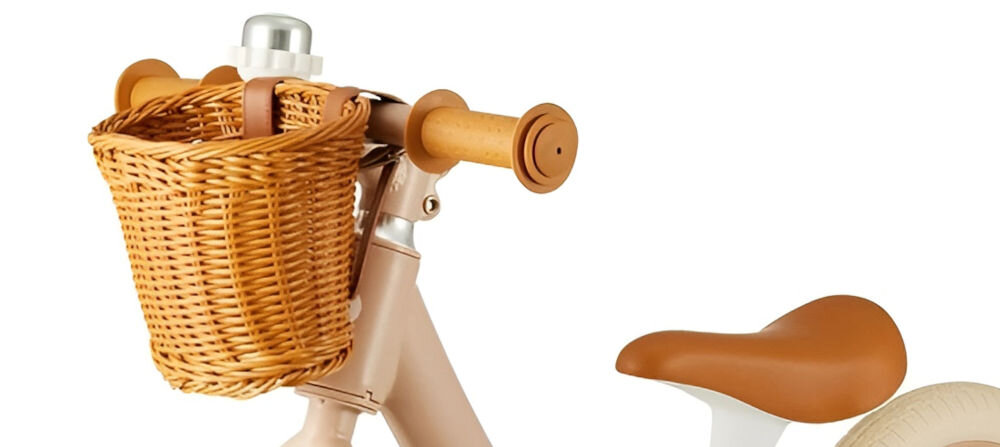 Rowerek biegowy KINDERKRAFT Rapid 2 Różowy białe tło zbliżenie na kierownicę brązowy koszyk dzwonek gumowe uchwyty dzwonek istotny dodatek praktyczne rozwiązanie sygnalizowanie swojej obecności charakterystyczny dźwięk dzwonka prawdziwi mistrzowie dwóch kółek