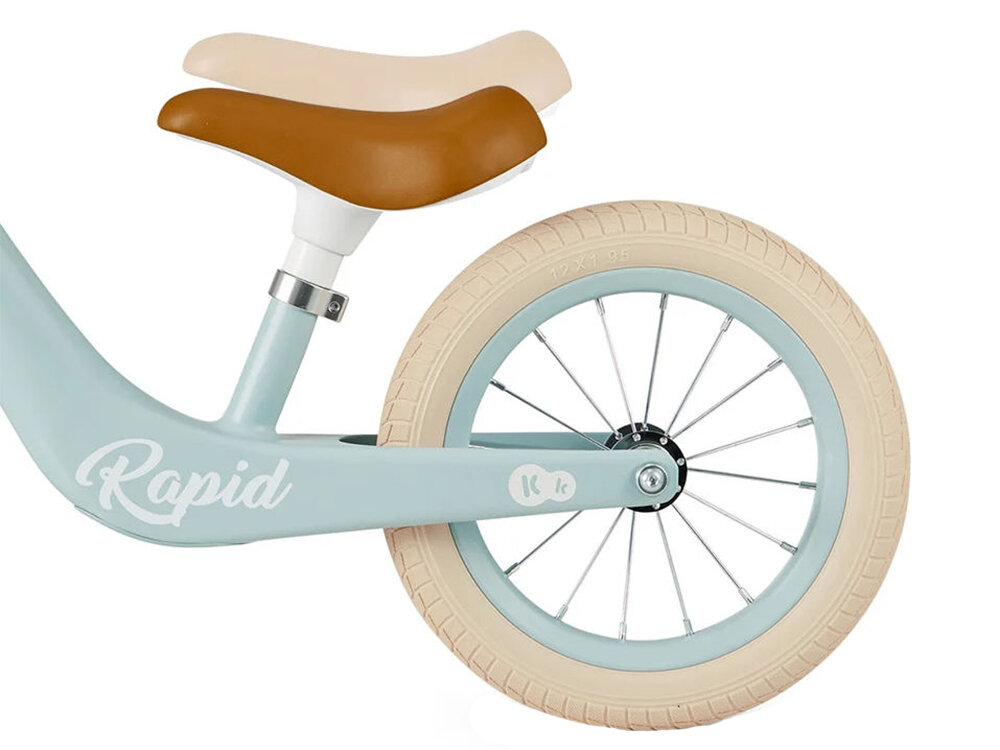 Rowerek biegowy KINDERKRAFT Rapid 2 Różowy białe tło zbliżenie na brązowe siodełko regulacja niebieska kolorystyka  jasne koło możliwość regulacji wysokości siodełka od 33,5 do 41,5 cm przez kilka sezonów „rośnie” wraz z maluchem Miękkie ergonomiczne siodełko intuicyjna regulacja 