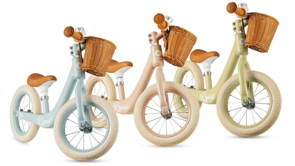 Rowerek biegowy KINDERKRAFT Rapid 2 Różowy białe tło trzy kolory rowerków niebieski różowy zielony brązowe koszyczki gumowe uchwyty dzwonki w trzech stylowych, pastelowych odcieniach delikatne wykończenie urok praktyczny wybór podkreślenie wyjątkowego charakteru niepowtarzalny styl 