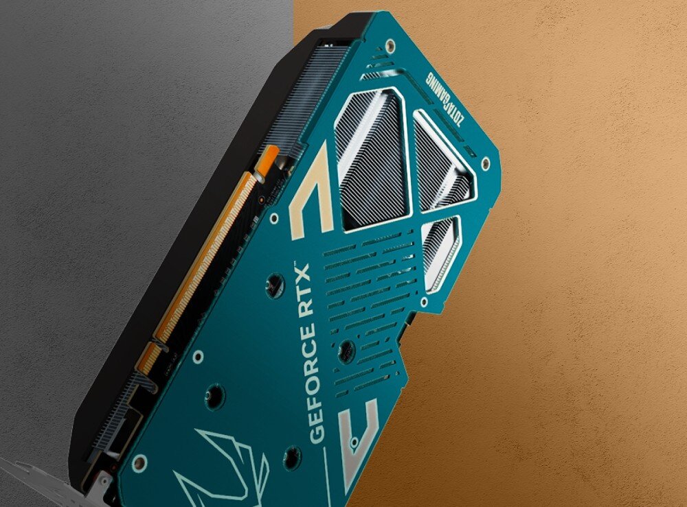 Karta graficzna ZOTAC Gaming GeForce RTX 5060 Ti Twin Edge OC 8GB Widok z tyłu na metalowy backplate karty graficznej w odcieniu turkusowym z wycięciami wentylacyjnymi i białymi grafikami. Tło to podzielona na pół powierzchnia w kolorze szarym i beżowym, metalowy backplate, konstrukcja, wytrzymałość