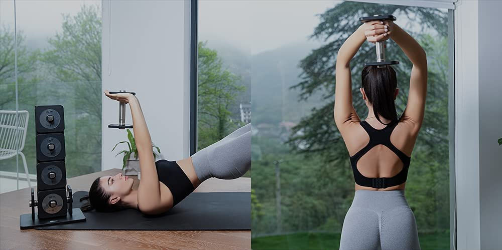 Osoba ćwiczy z hantlami w jasnym pomieszczeniu z dużymi oknami, przez które widać zalesiony krajobraz. Obok znajduje się stojak z kilkoma hantlami ułożonymi pionowo.