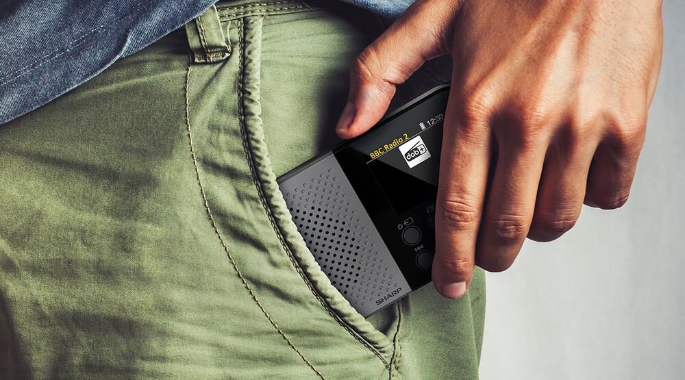 SHARP DR-P520 radio mobilne kompaktowe mocowanie do paska słuchanie w ruchu, osoba wkładająca radio do kieszeni