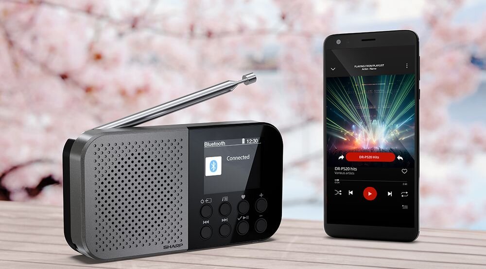 SHARP DR-P520 radio Bluetooth 5.3 streaming muzyki playlisty podcasty bez kabla, smartfon wraz z radiem stojące na drewenianym stole