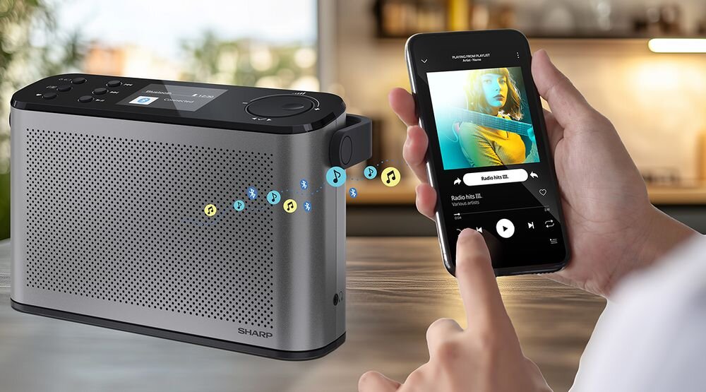 Radio SHARP DR-P540 Bluetooth 5.3 streaming muzyki bezprzewodowe audio stereo, radio stojące na drewnianym blacie, osoba trzymająca smartfon w rękach