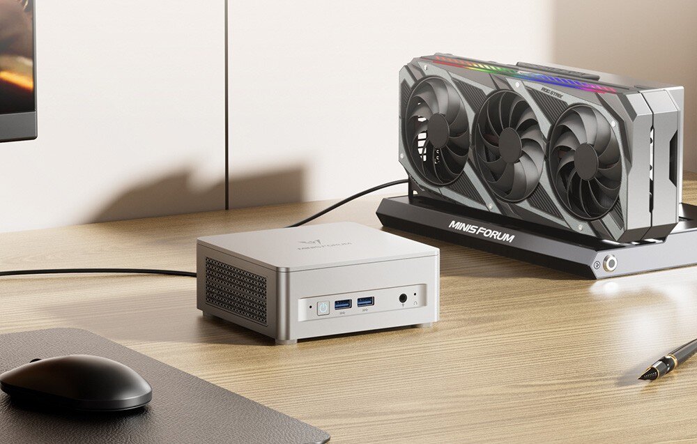 Komputer MINISFORUM UM870 Plus Mini PC Minisforum na biurku, połączony z zewnętrzną kartą graficzną na dedykowanej podstawce.